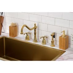 gold faucets and soap dispensers in a kitchen