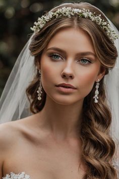 a woman wearing a wedding veil with flowers in her hair