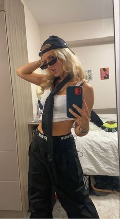 a woman taking a selfie in the mirror wearing black pants and a white top