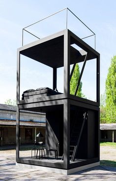 a black structure sitting in the middle of a park