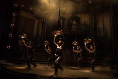 a group of people standing on top of a stage in front of a light fixture