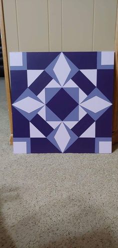 a blue and white painting sitting on top of a carpeted floor next to a wooden door