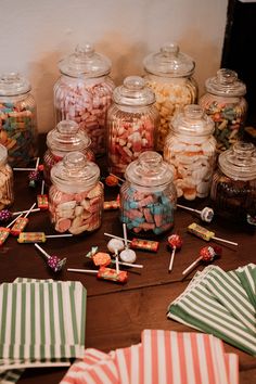 there are many candy in glass jars on the table