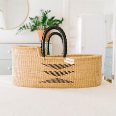 a basket sitting on top of a bed next to a mirror