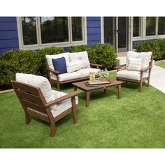 two chairs and a coffee table sitting on top of green grass