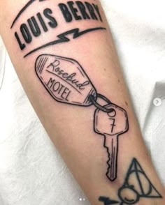 a person with a tattoo on their arm has a key and louis berry motel sign