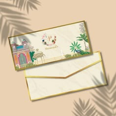 two envelopes sitting next to each other on top of a beige background with palm leaves