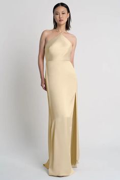 a woman in a long dress with an asymmetrical neckline and side slit