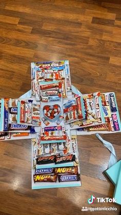 a cross made out of candy bars on top of a wooden floor