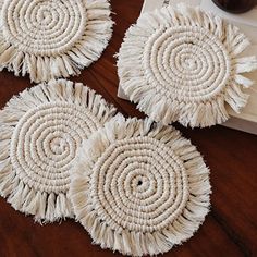 three white round doilys sitting on top of a table next to a candle