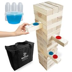 a wooden tower with plastic cups and bags on the side, next to it's contents