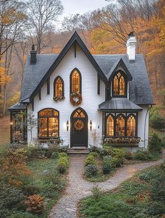 a white and black house with lots of windows on it's front porch in the fall