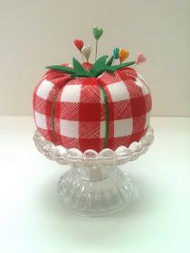 a red and white checkered cake sitting on top of a glass pedestal