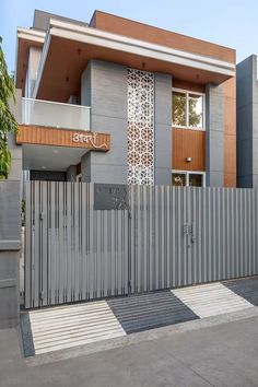 a modern house with an iron fence and gate