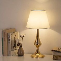 a lamp that is sitting on top of a table next to books and a book