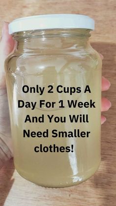 a person holding a jar with the words only 2 cups a day for 1 week and you will need smaller clothes