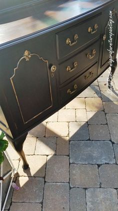 an old dresser is painted black and has gold trimmings on the top drawer