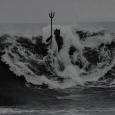 a black and white photo of a person on a surfboard in the middle of a wave