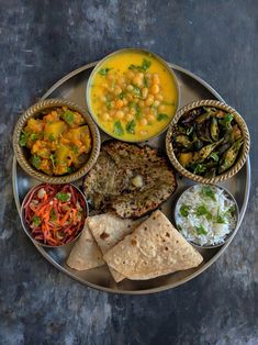 a plate full of different types of food on a metal tray with rice, beans and other foods