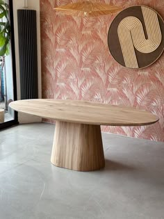 a wooden table sitting in front of a pink wall