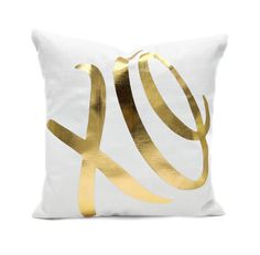 a white and gold pillow with the word love in gold foil on it's side