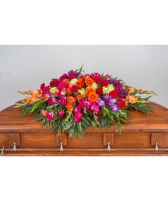 a wooden casket filled with lots of colorful flowers