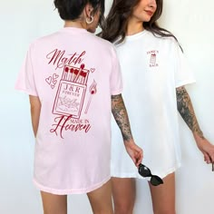 two women standing next to each other with tattoos on their arms and one wearing a pink shirt