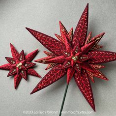 two red paper flowers sitting next to each other