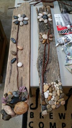 two wooden planks with rocks and twigs on them sitting on a table next to magazines