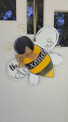 a bee door hanger with the words, the sunshine is out and a hat on it