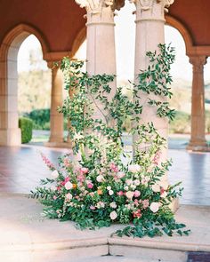 flowers and greenery are growing on the pillars