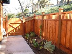 a wooden fence is next to a small garden