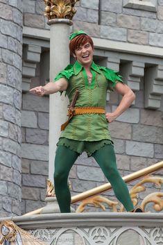 a woman dressed as peter panton on top of a building in front of a lamp post