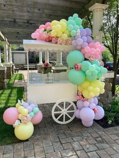 an ice cream cart decorated with balloons and flowers