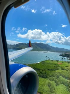 the view from an airplane window looking out at water and mountains