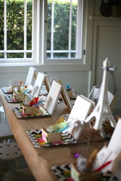 several easels are sitting on a table with art supplies in front of the window