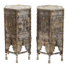 pair of ornately carved wooden side tables with metal decorations on the tops and sides