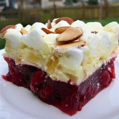 a piece of cake sitting on top of a white plate covered in whipped cream and fruit