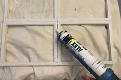 a person holding a paint roller in front of a window