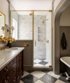 a bathroom with a checkered floor and marble counter tops, along with a walk in shower