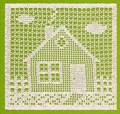 a green and white doily with a house on it