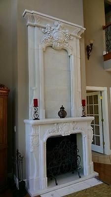 a white fireplace with candles on it in a living room