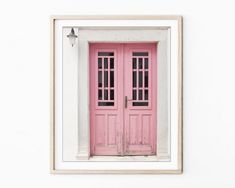 a pink door with two panes in front of it on a white wall above a wooden frame