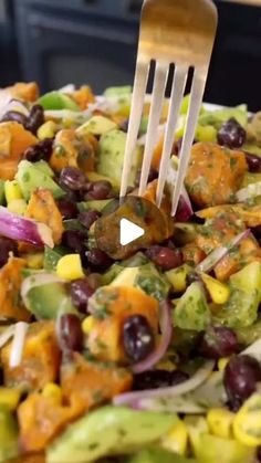 a fork is stuck into a salad with beans and avocado