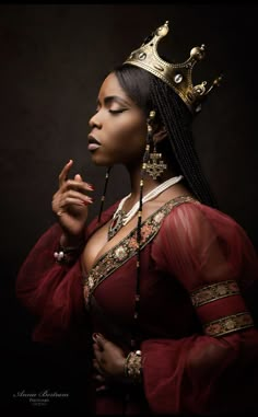 a woman in a red dress with a crown on her head and beads around her neck