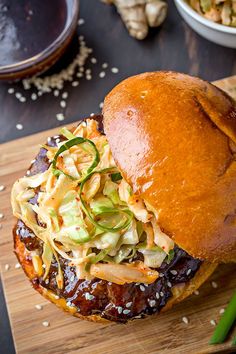 a bbq sandwich with cole slaw on a wooden cutting board