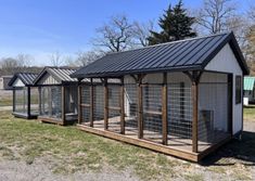 a group of small chicken coops sitting on top of a grass covered field