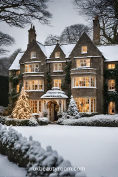 a large house covered in snow with christmas lights on the windows and trees around it