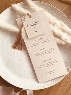 a white plate topped with a menu on top of a wooden table