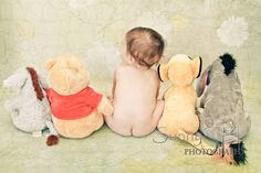 a baby is sitting between four stuffed animals